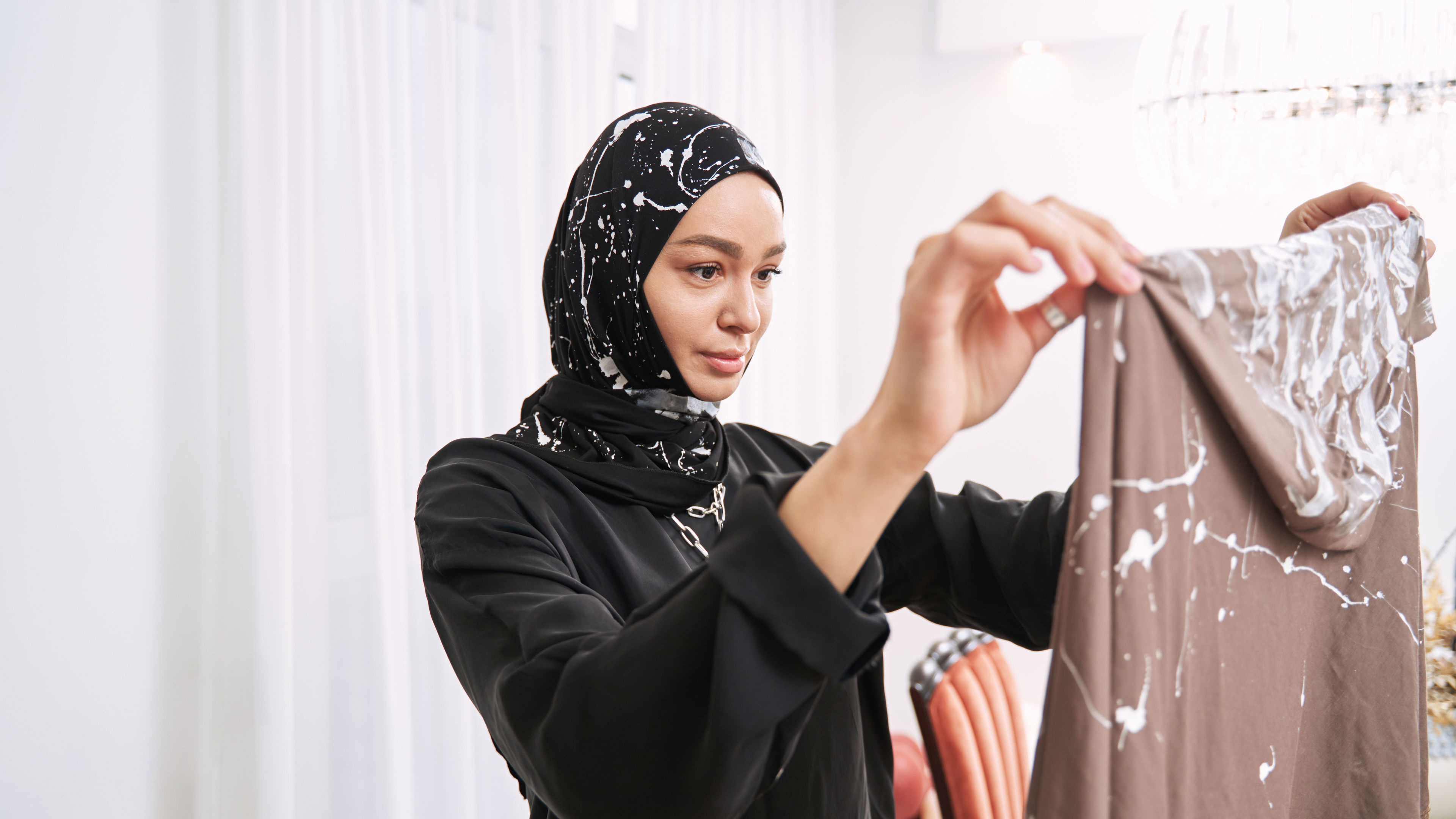 A woman looking at a hijab 
