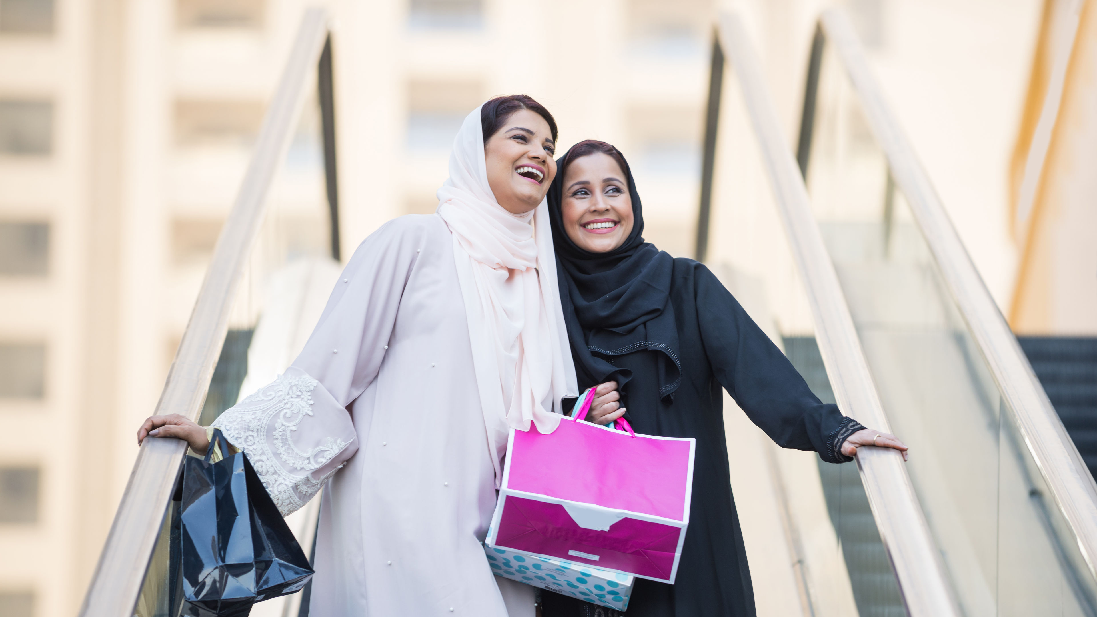 Arabic women shopping outdoors in Dubai - Girls with traditional arabian dress having fun 