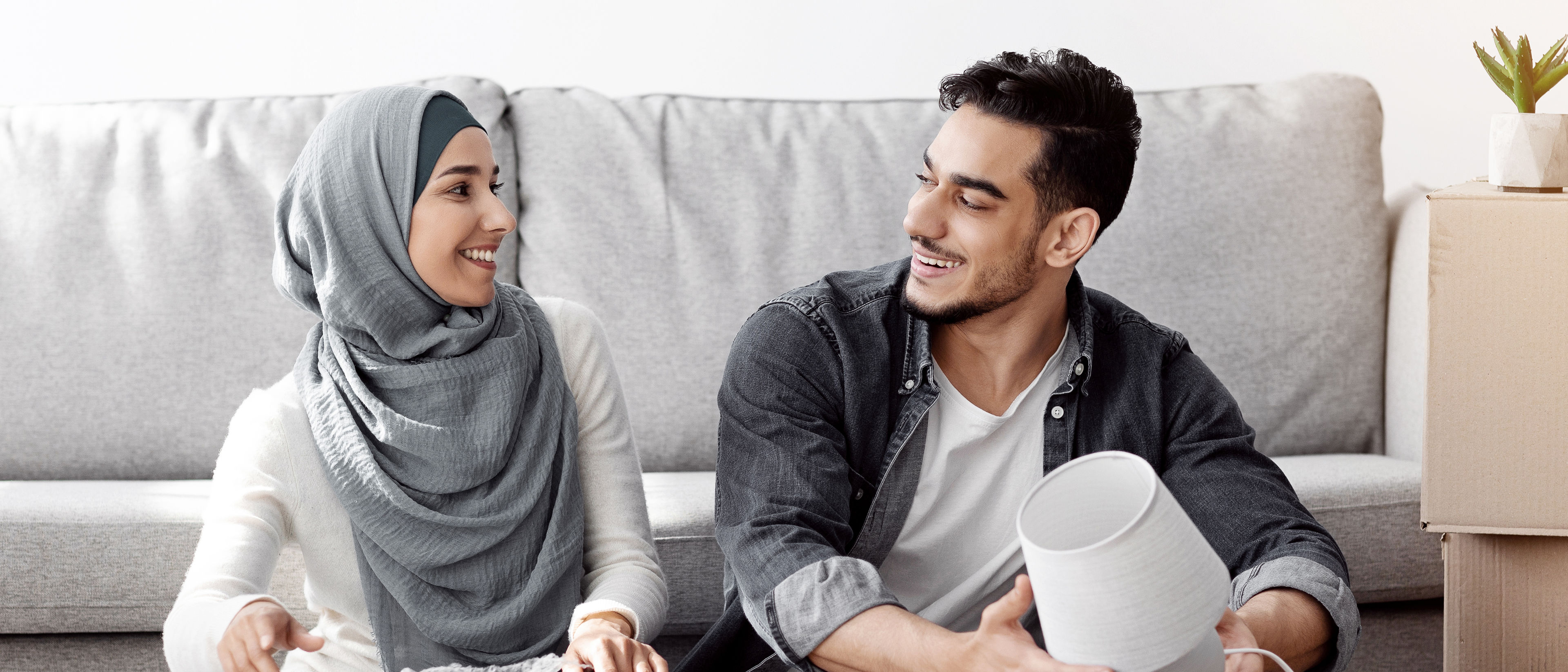 Cheerful arab family unpacking belongings, moving to new apartment home